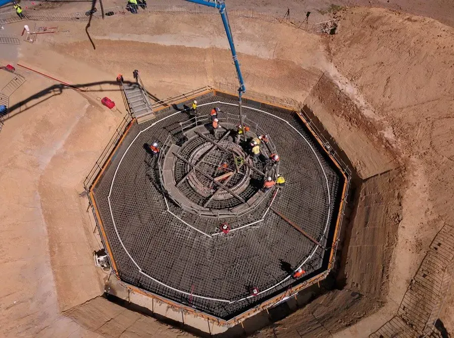 An aerial view of a construction site with workers in a circle.