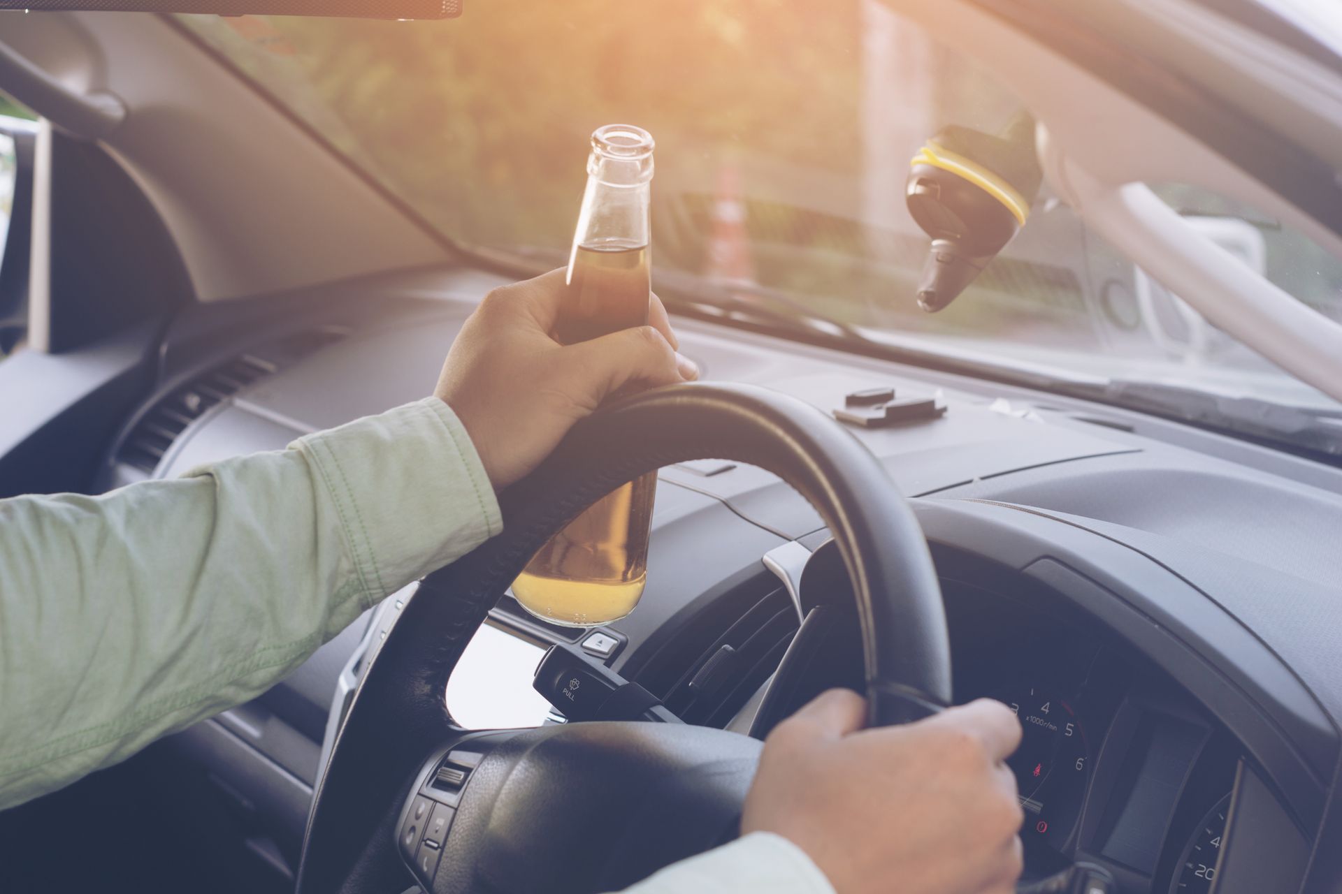 Driver holding bottle while operating vehicle.