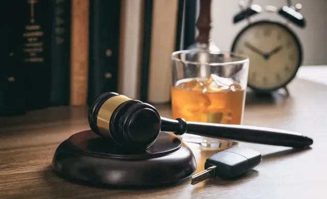 DUI lawyer concept image with judge gavel, whiskey glass, car keys, law books, and clock on desk. DUI lawyer concept image with judge gavel, whiskey glass, car keys, law books, and clock on desk.