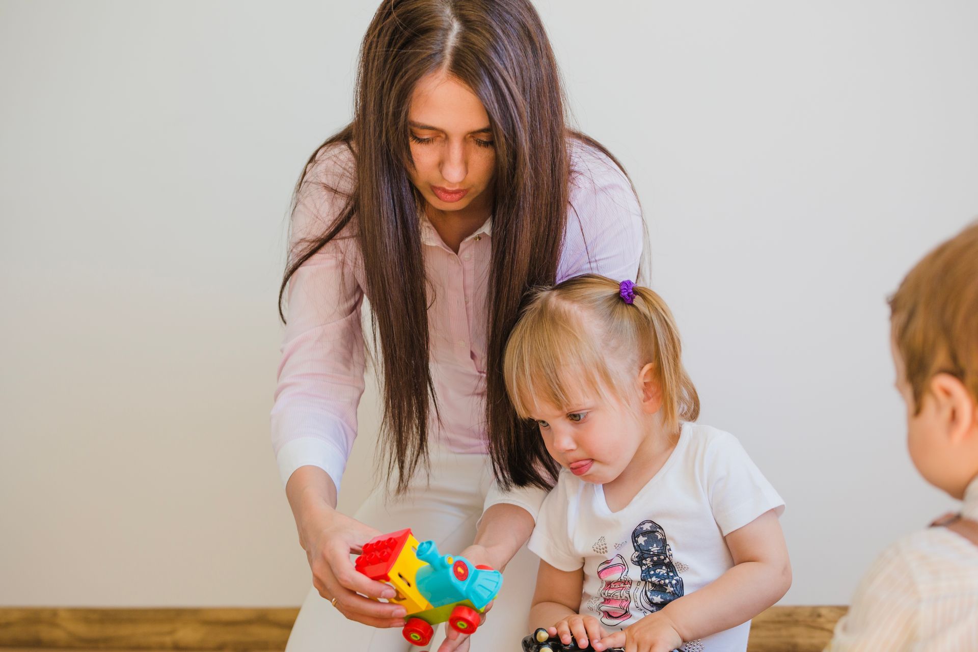 An RBT and a child are playing with blocks on the floor during an in-home aba therapy session