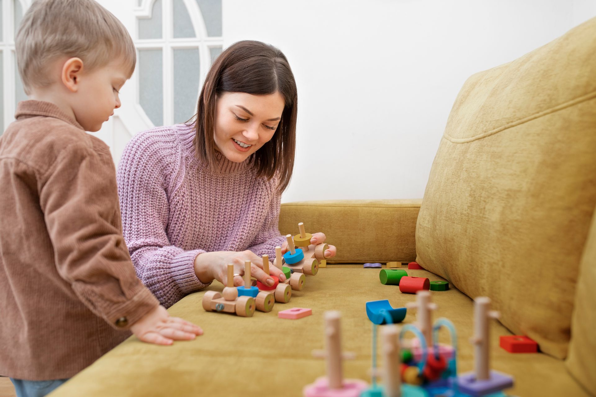 An RBT and a child are playing with blocks on the floor during an in-home aba therapy session