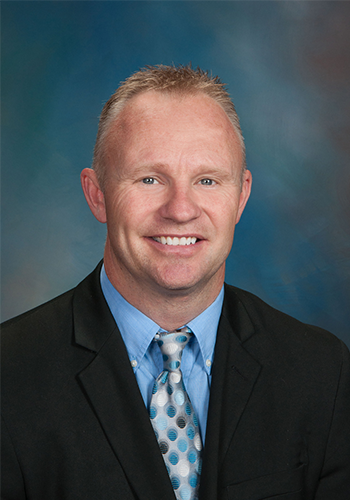 A man in a suit and tie is smiling for the camera.