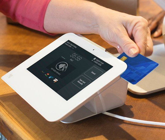 A person is using a tablet to pay with a credit card