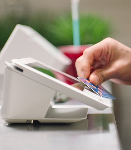 A person is inserting a credit card into a machine.