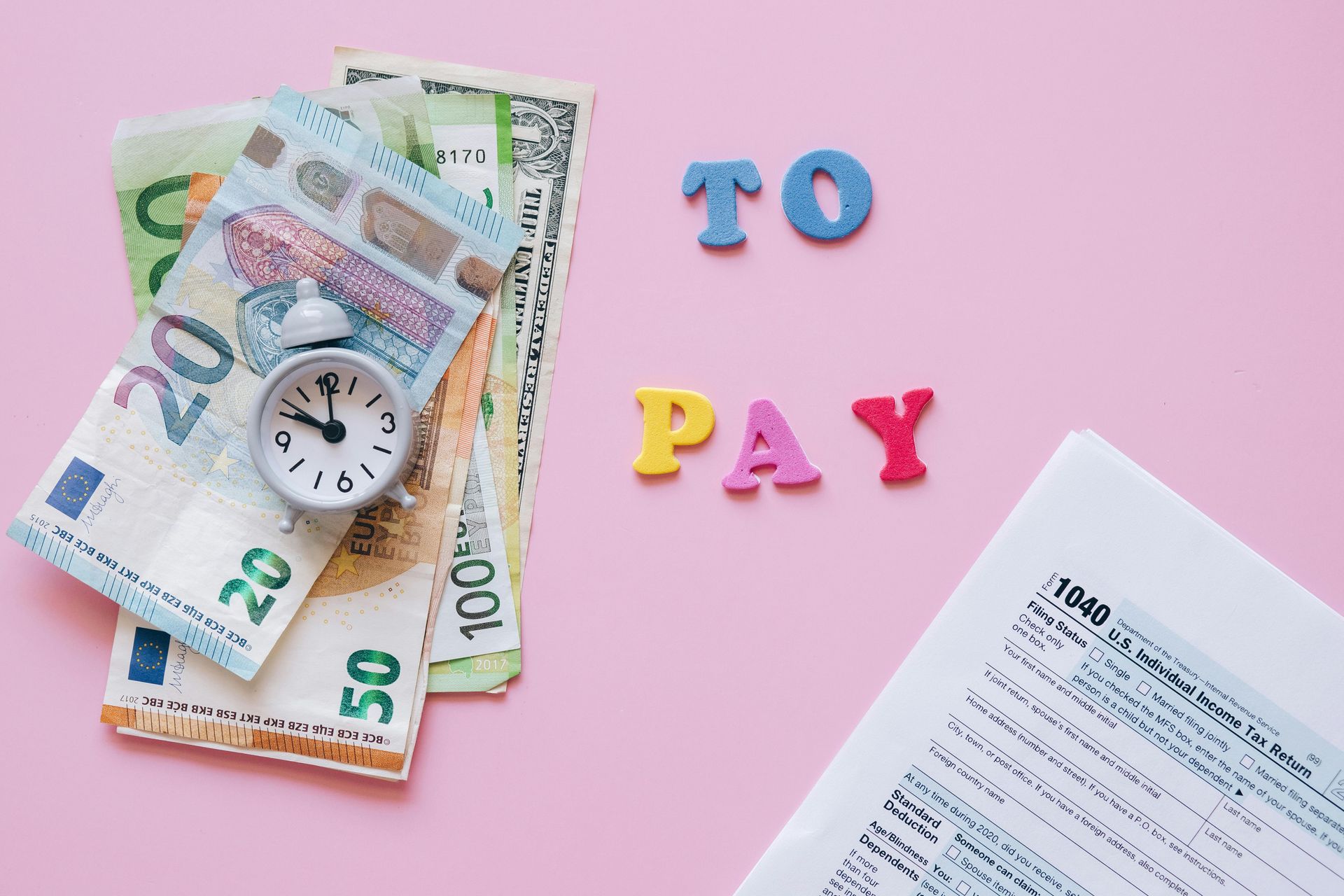 Money, alarm clock, and tax form with