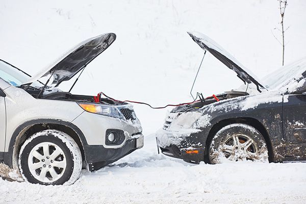 Two cars nose-to-nose in deep snow, both hoods open after a collision. | Jeff's Automotive, Inc