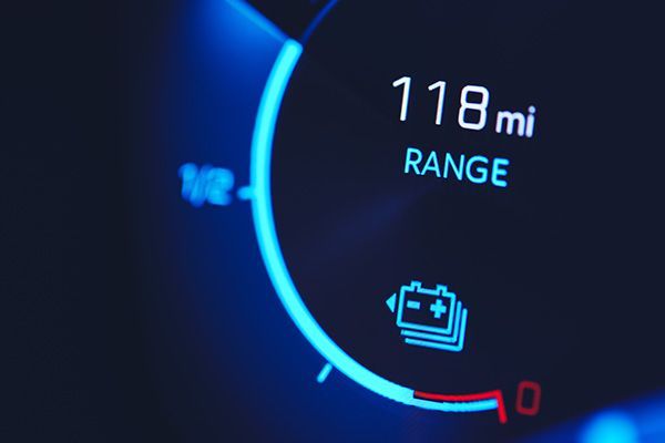 Car dashboard display showing 118 mi range and a low battery warning icon on a blue gauge | Jeff's Automotive, Inc