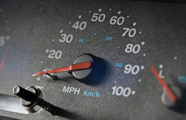 Close-up of a car speedometer in MPH and km/h with a red needle and a black knob. | Jeff's Automotive, Inc