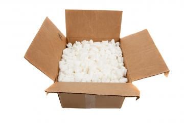 An open, brown cardboard shipping box filled with white foam packing peanuts.