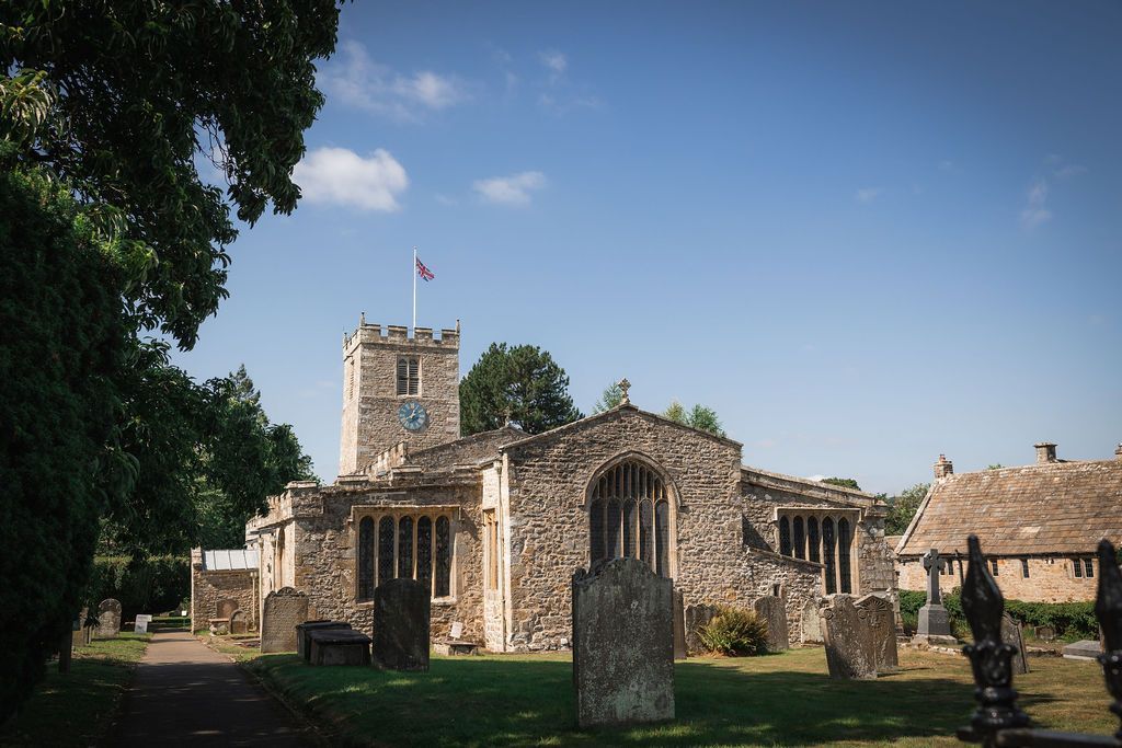 Stone ruins of an old church or castle in a sunny grassy field under a blue sky