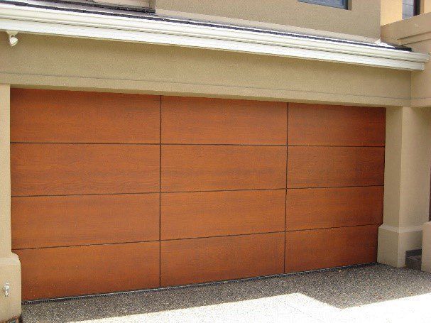 Closed orange garage door on a beige building exterior