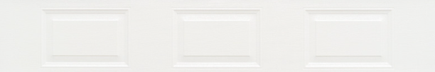 White paneled wall with subtle rectangular molding details in a light, neutral interior.