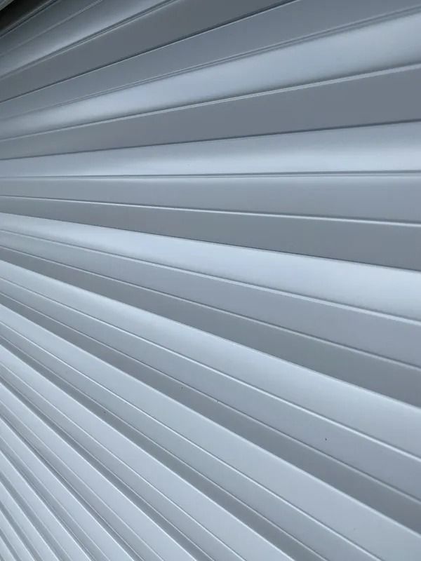 Close-up of white horizontal blinds with light and shadow lines