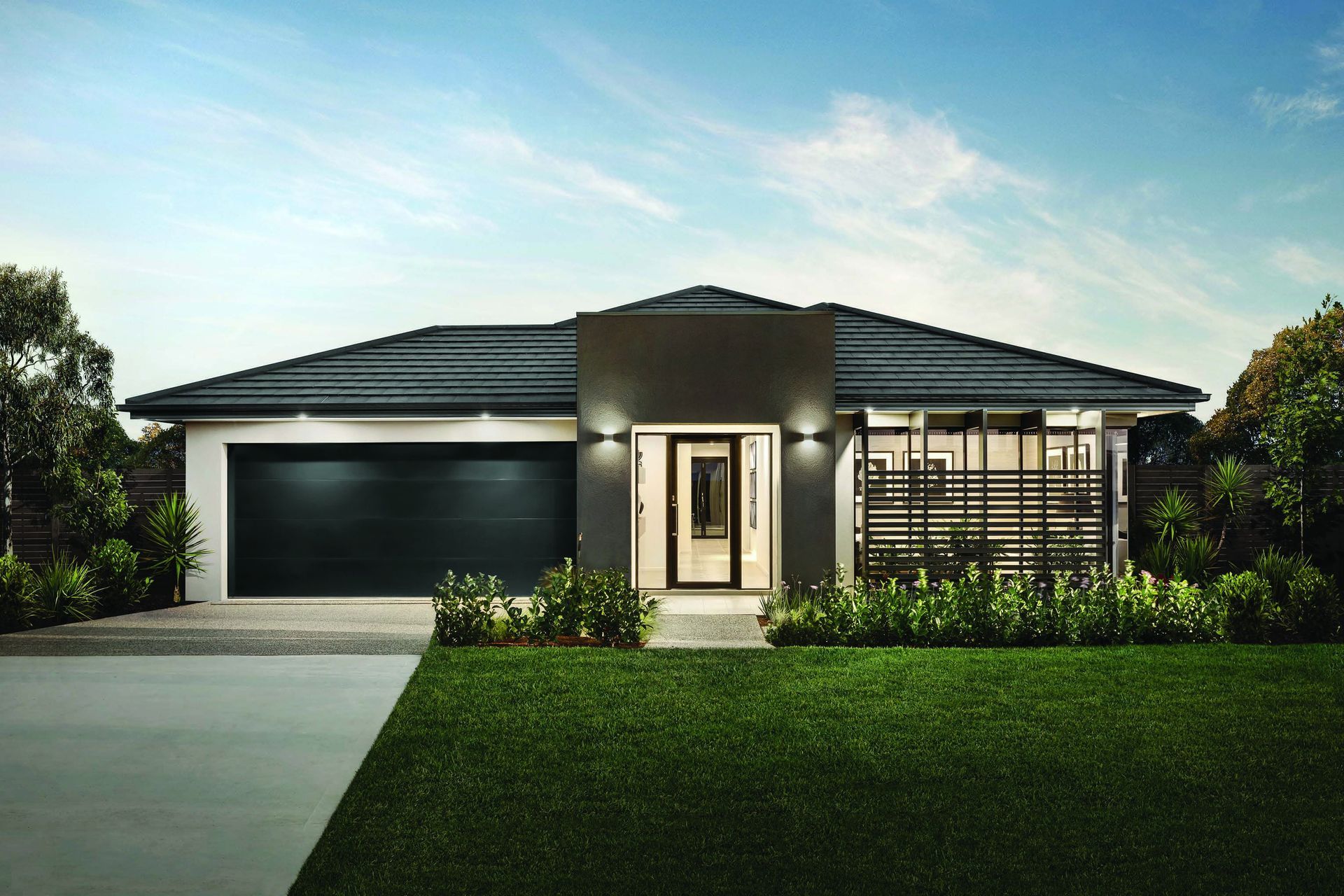Closed metal garage door behind a green hedge and paved walkway