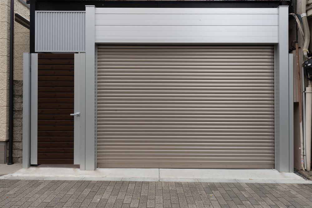 Closed beige garage door beside a dark wooden entrance on a narrow urban building facade