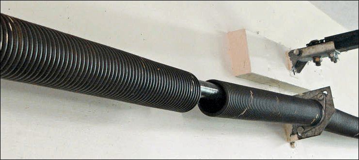 Black corrugated hose connected to a broken duct fitting on a wall-mounted bracket