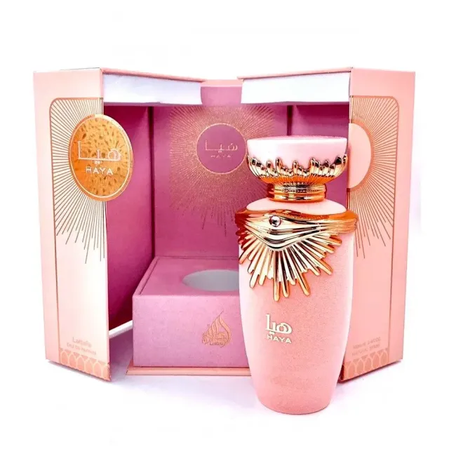 Frasco de perfume rosa en caja decorativa con detalles dorados.