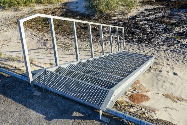Steel ramp with handrail from embankment to beach
