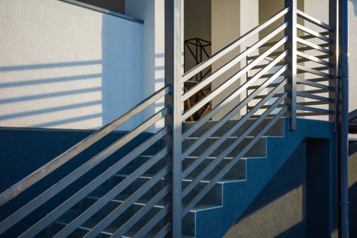 Industrial stairway with sleek metal railings and white wall
