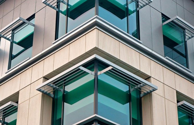 Commercial building corner with green windows and aluminum awnings