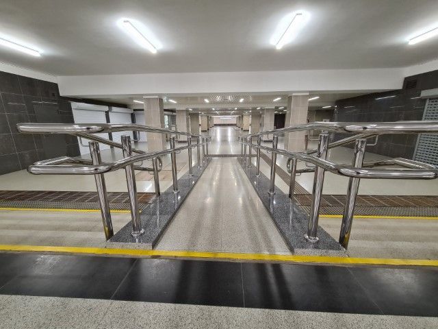 Underground station showing metal rails and accessibility ramp
