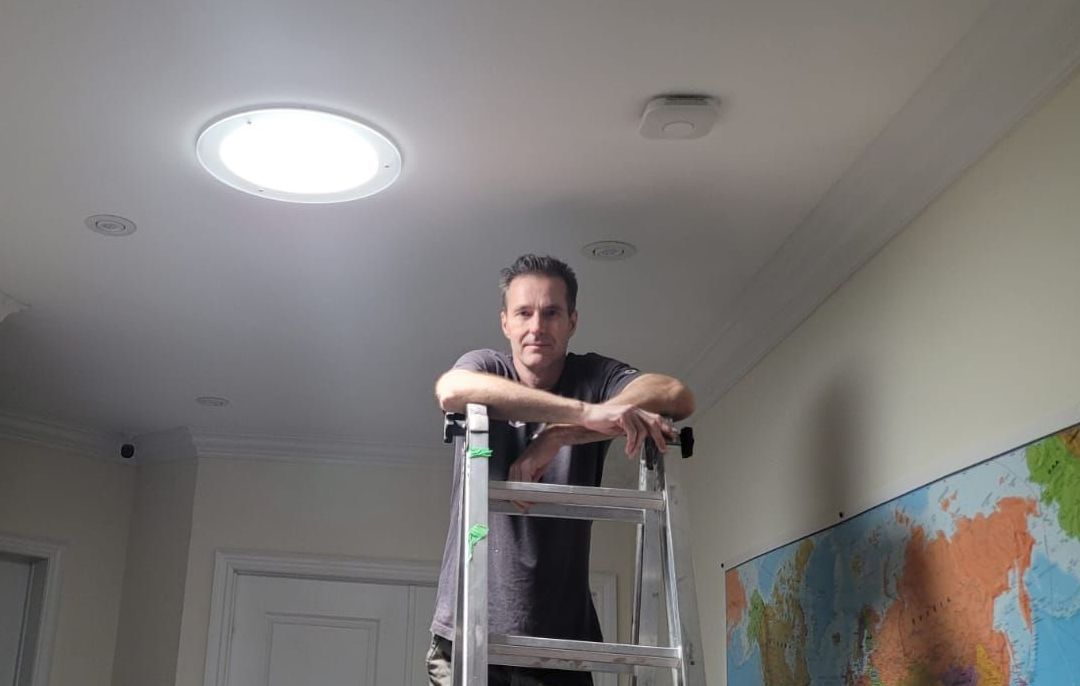 Picture of John Hewit Solatube Installer on a roof performing a skylight solar panel install