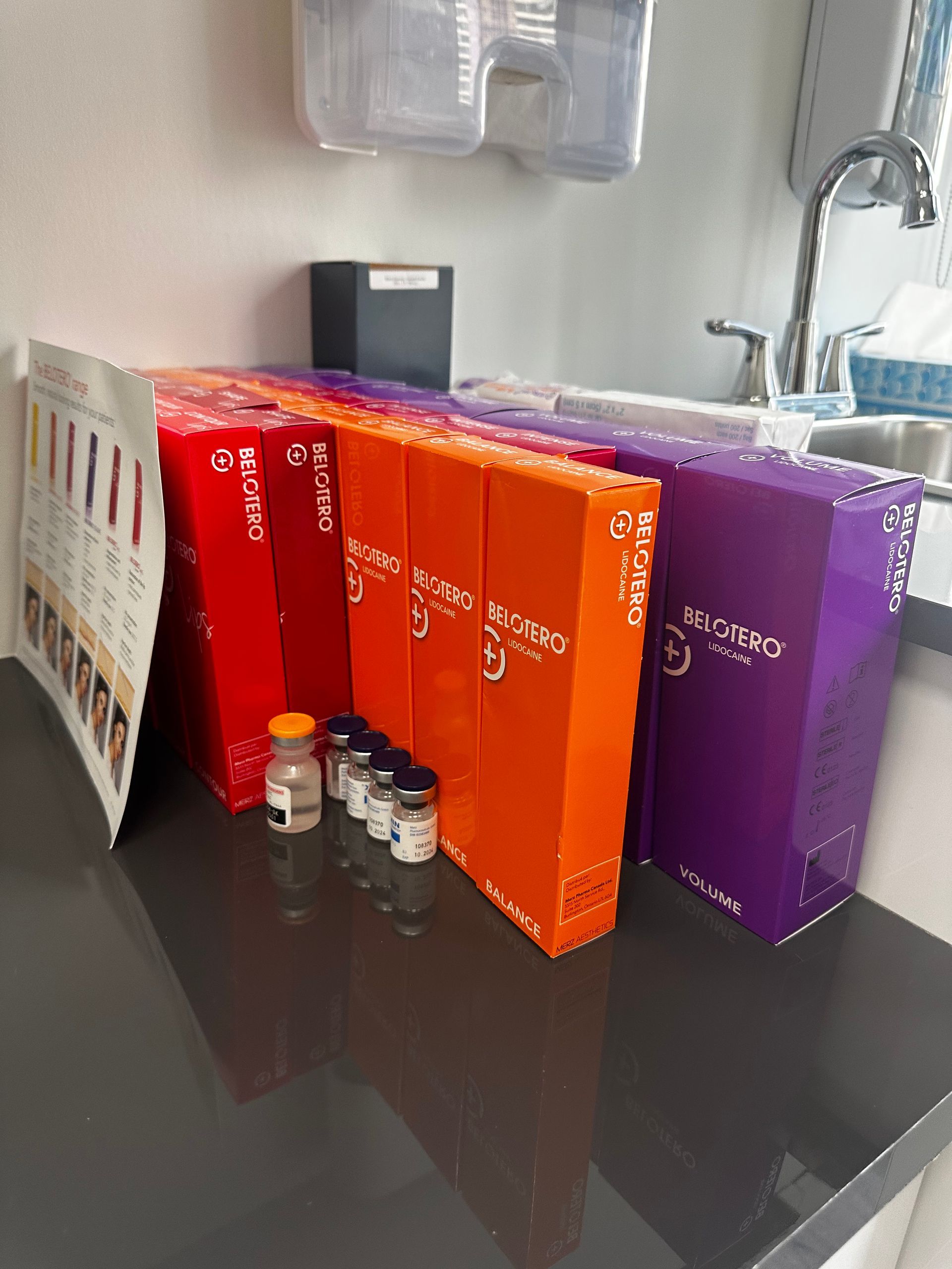 A row of boxes sitting on top of a counter next to a sink.