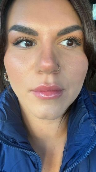 A close up of a woman 's face with a nose ring.