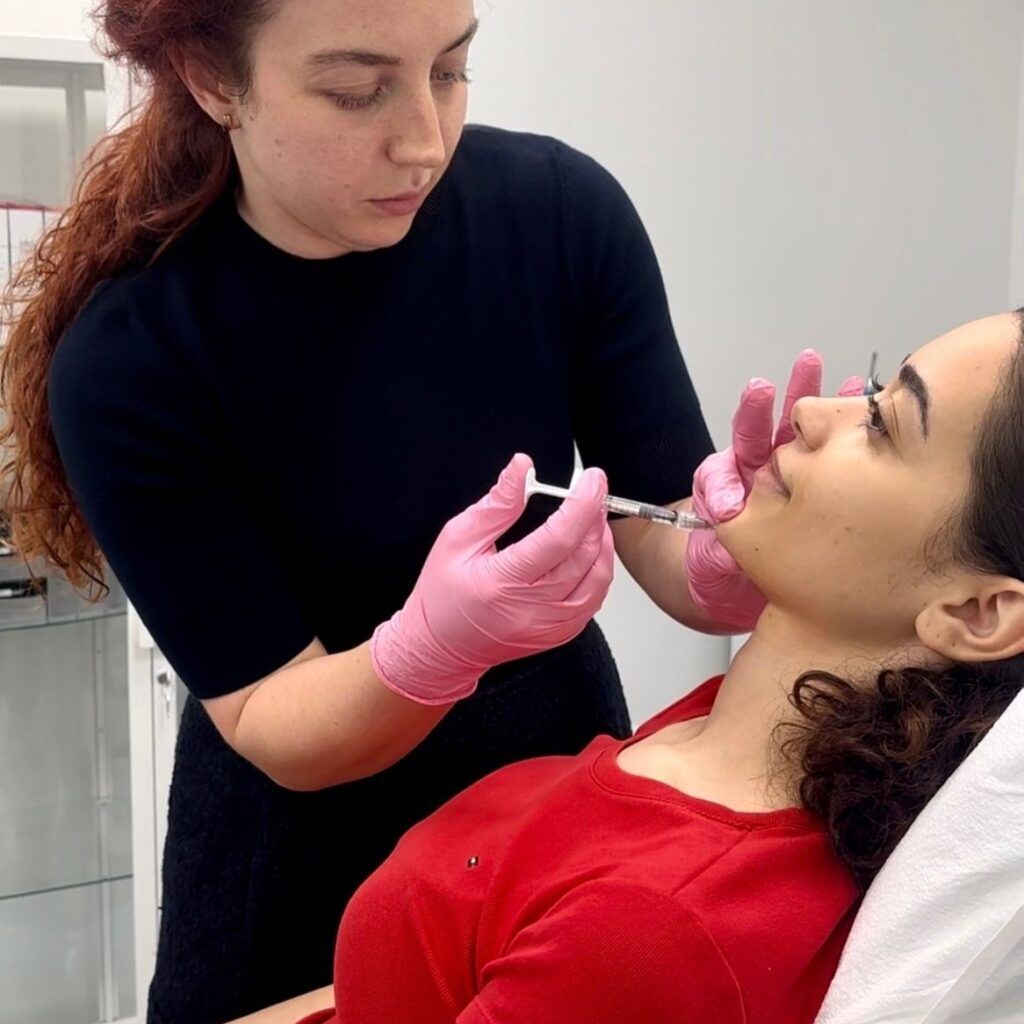 A woman is getting a botox injection in her face.