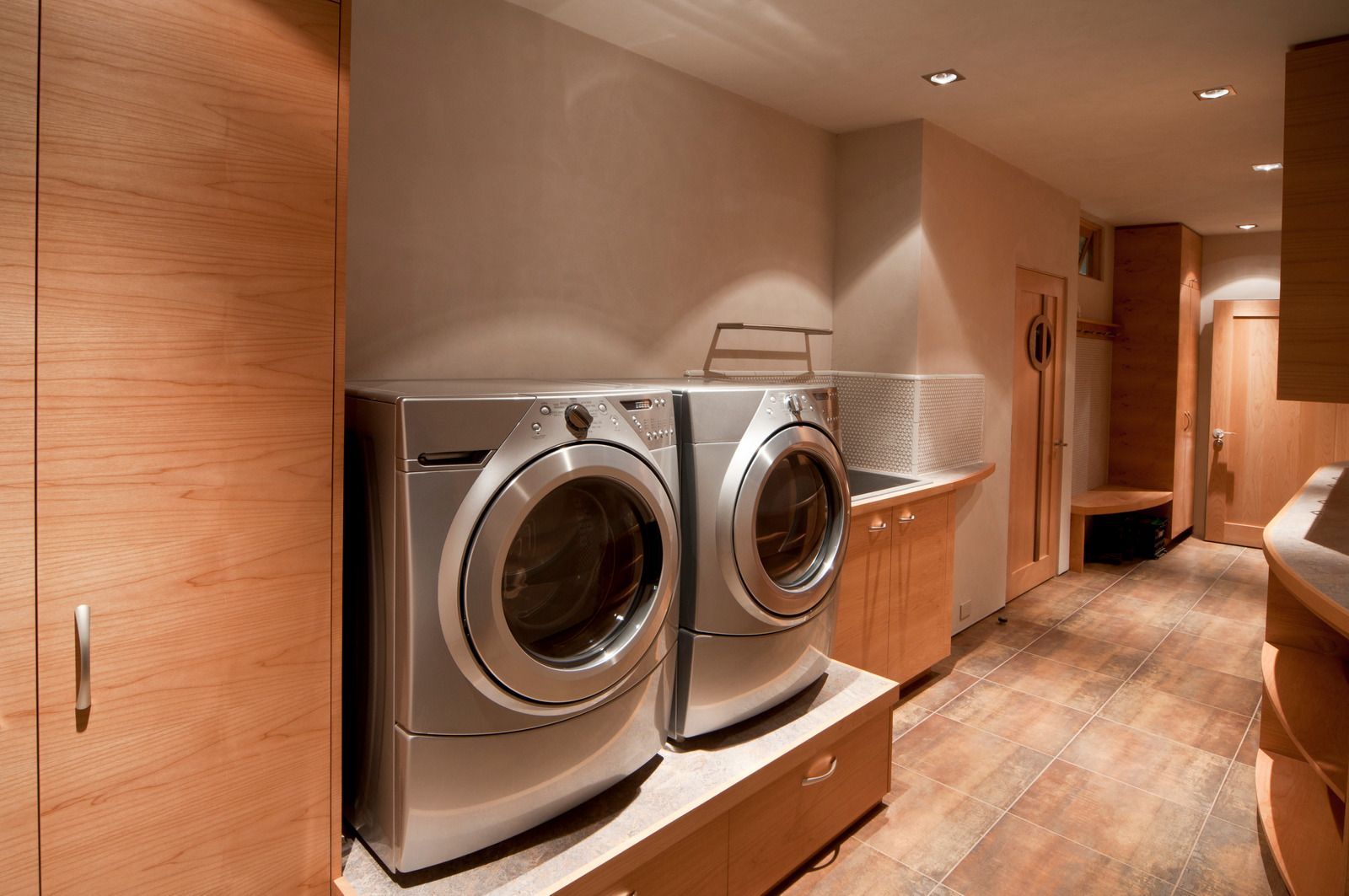 A laundry room with two washers and two dryers