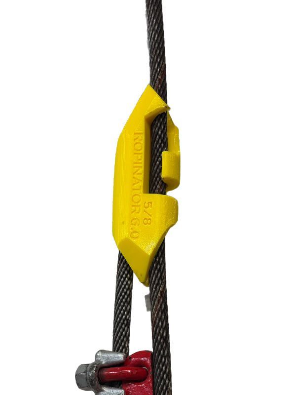 A yellow object is attached to a wire rope.