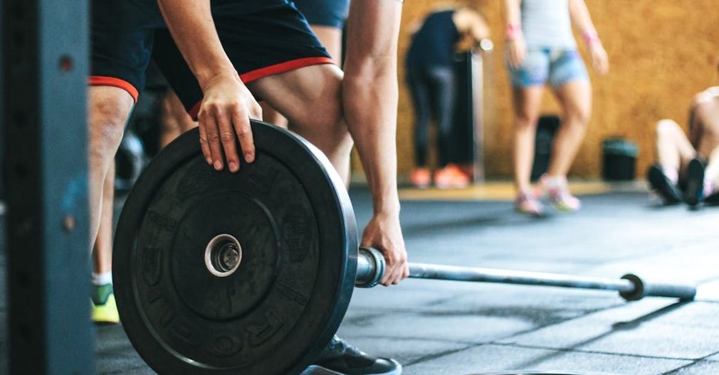 A man lifting weights onto a bar at the gym