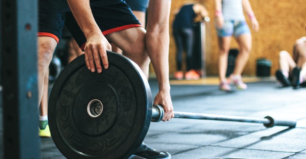 A man lifting weights onto a bar at the gym