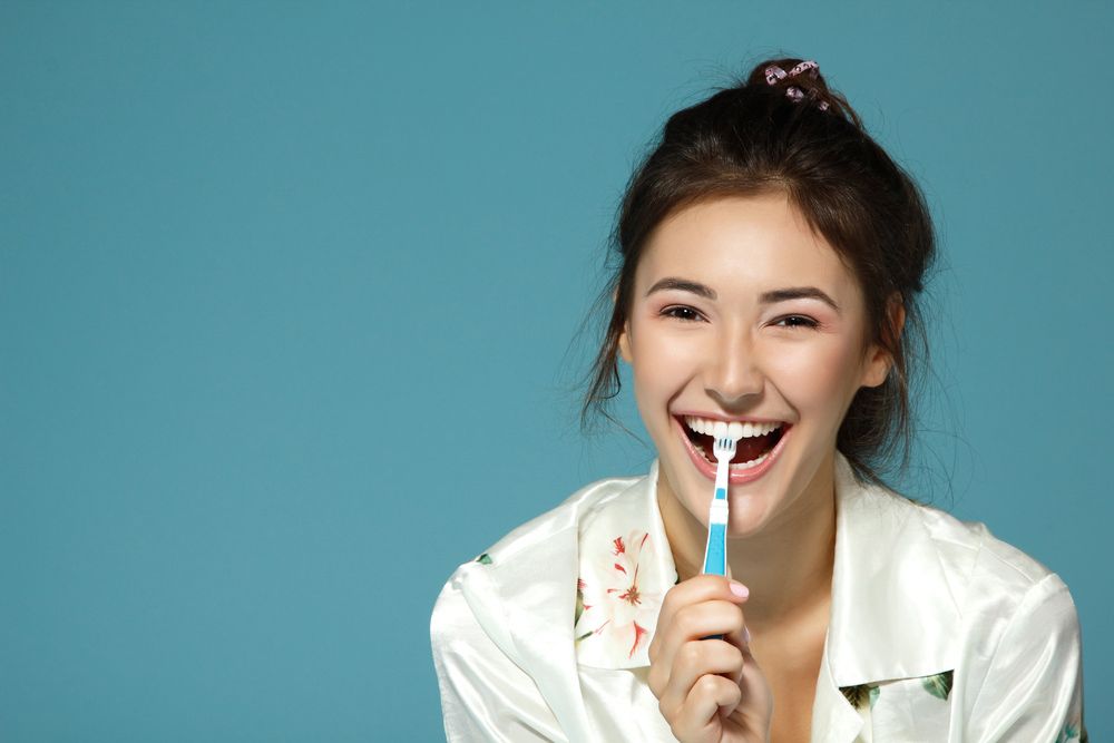 Happy Woman Brushing Her Teeth — Dental Clinic in Mooloolaba, QLD
