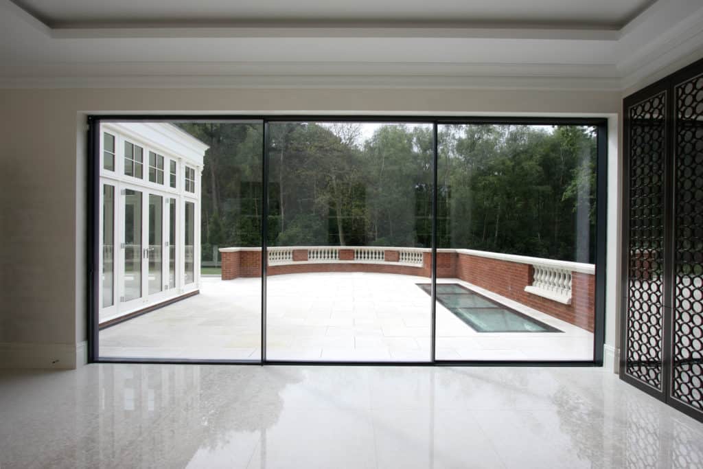 An empty room with a large window looking out to a pool