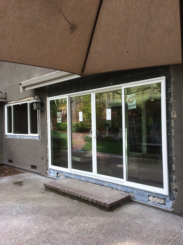 A house with a lot of windows and an umbrella in front of it.