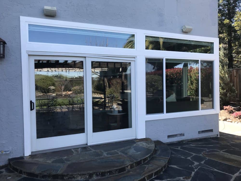A house with a large window and sliding glass doors