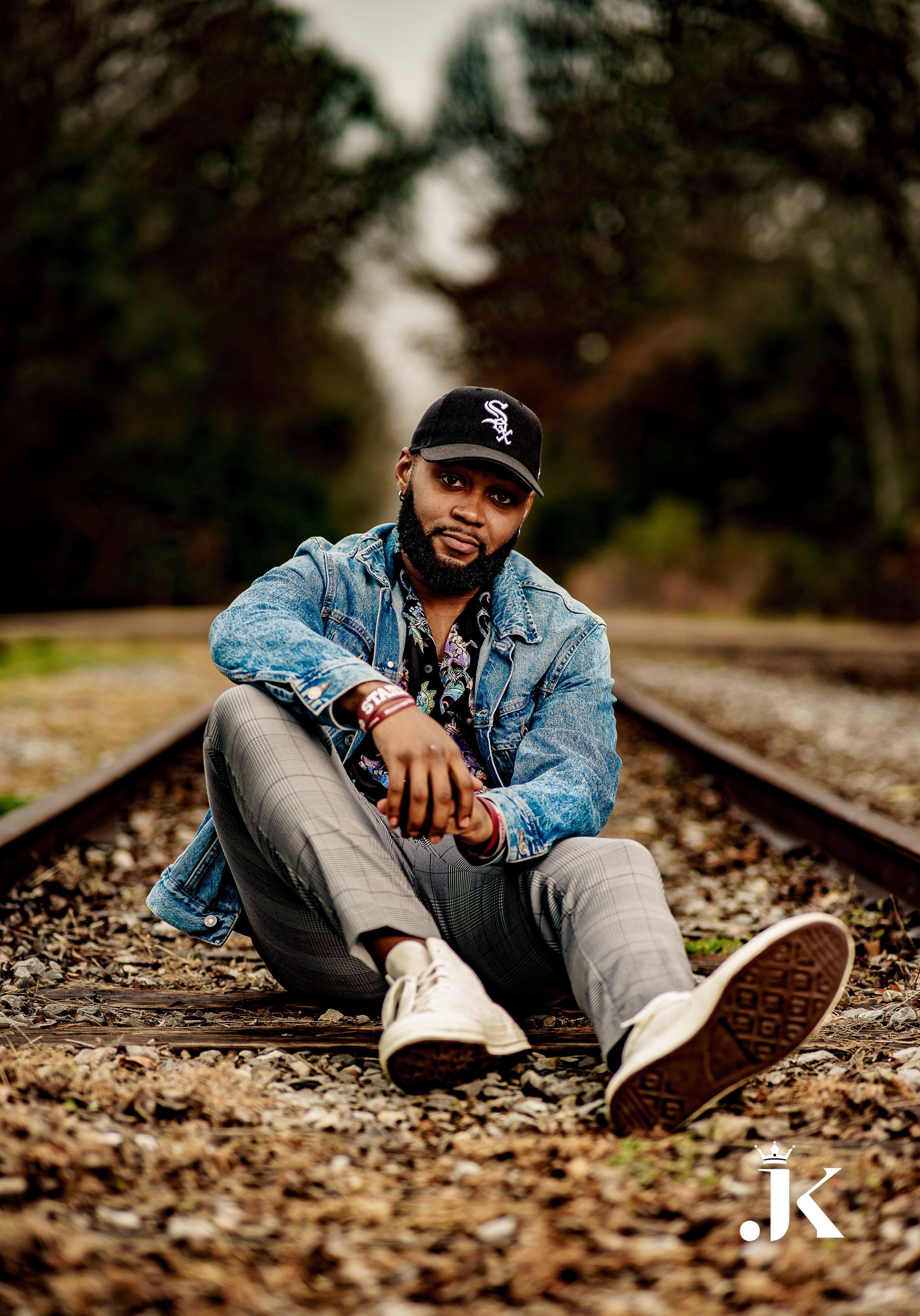 A man is sitting on a train track.