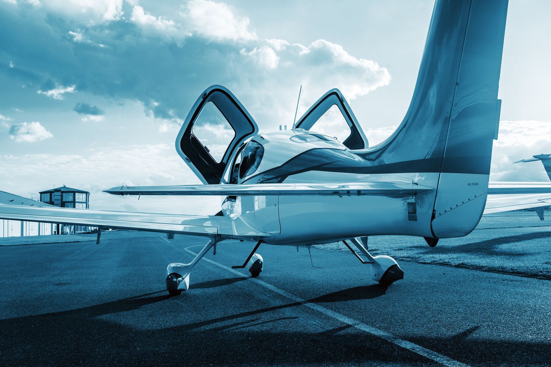 A small plane is parked on a runway with its doors open.