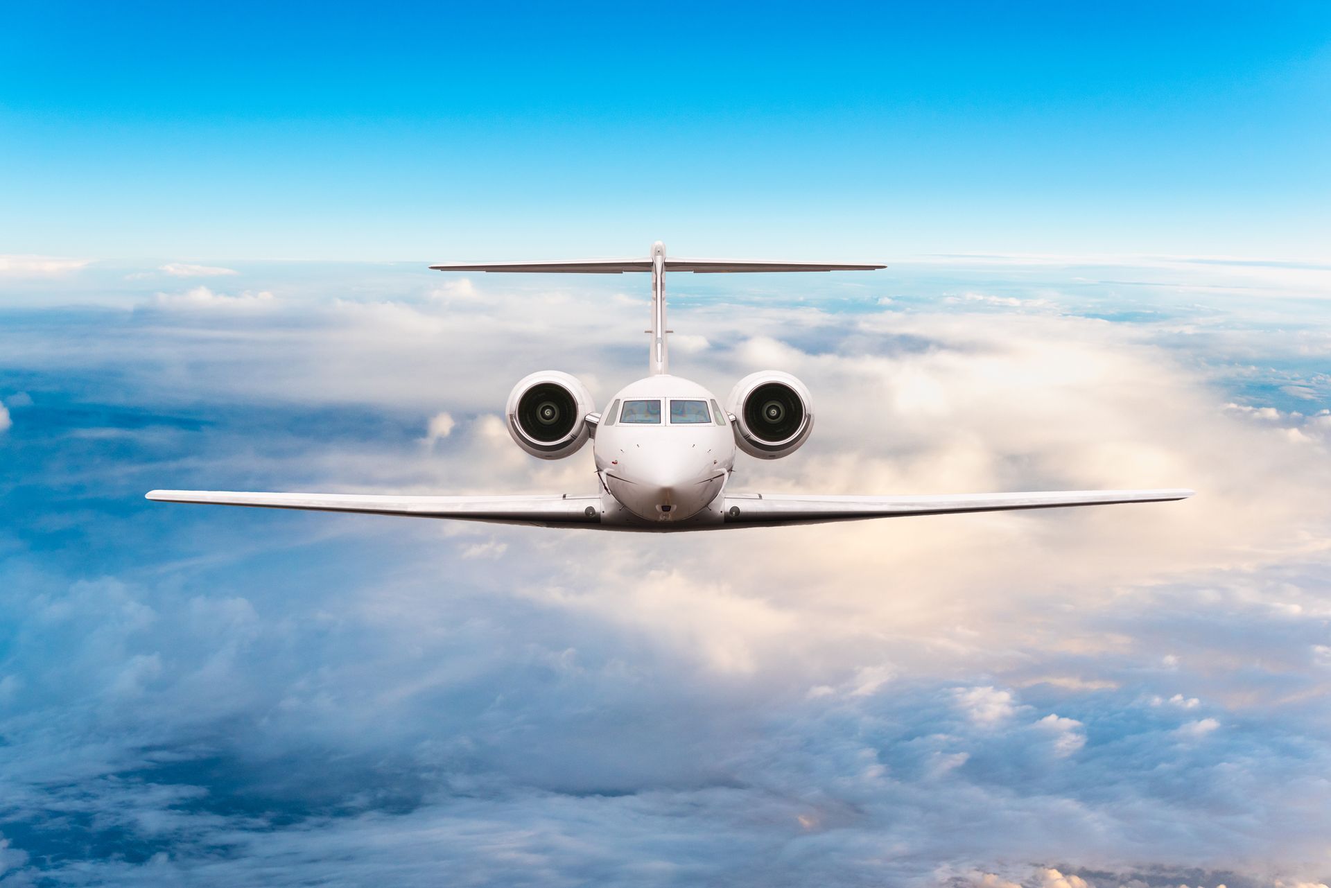 A private jet is flying through the clouds in the sky.