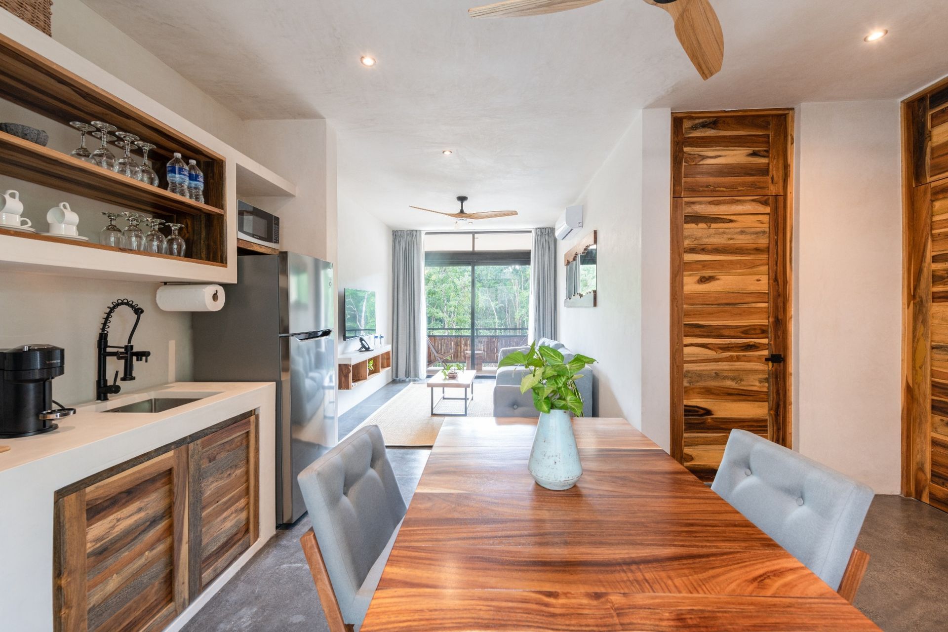 Dining room table with kitchen looking into living room area of apartment