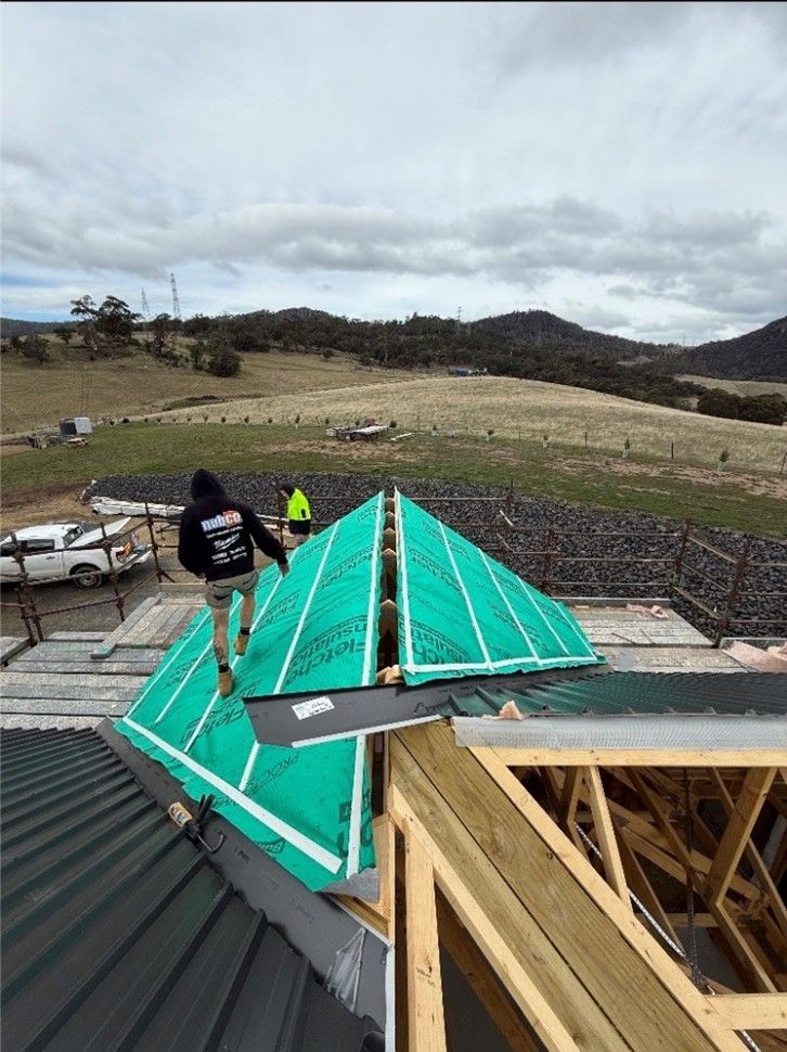 Builder working on roof of new building. Builder working on roof of new building.