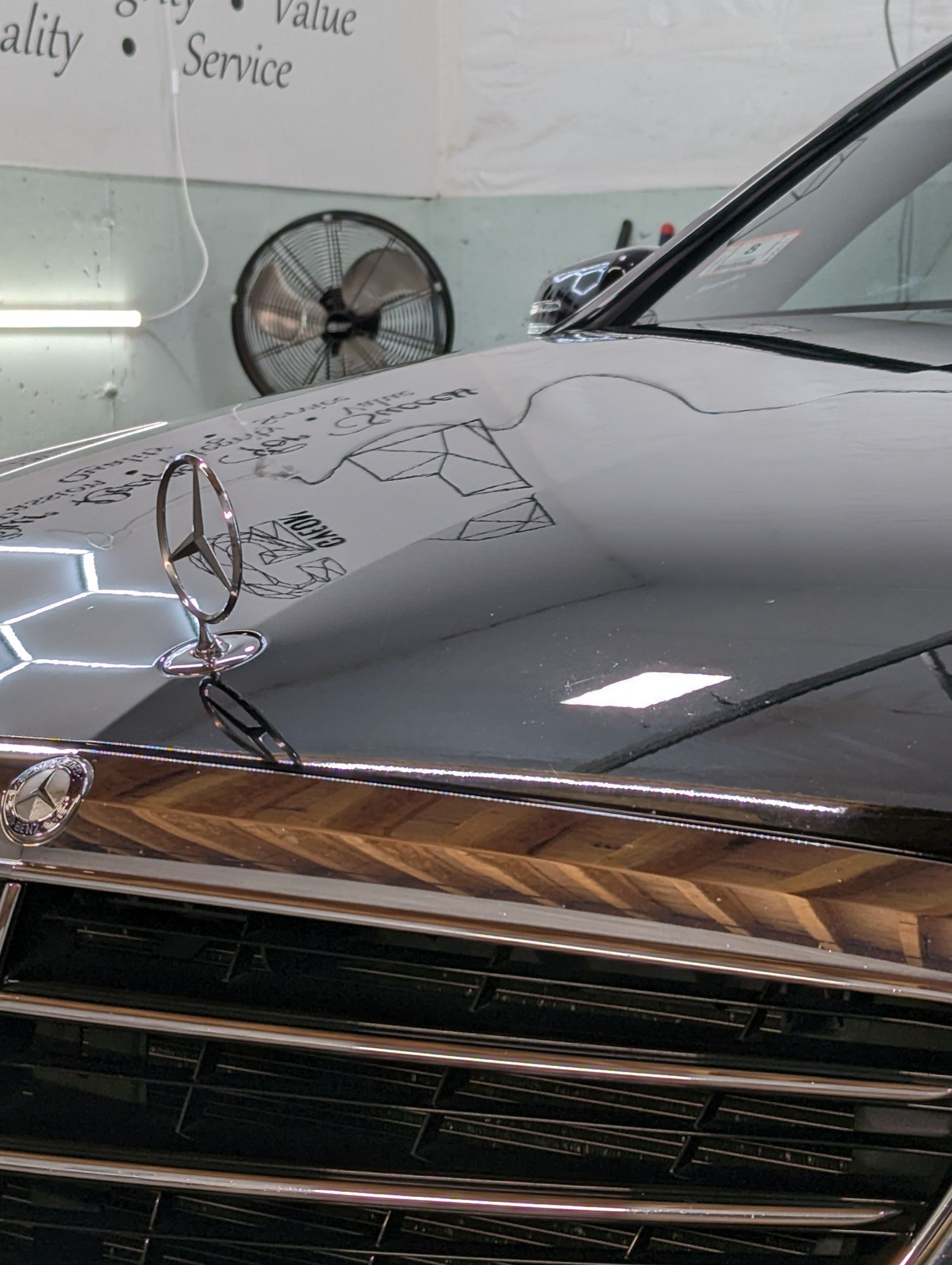 Ceramic Coating - A close up of a car hood with a mercedes logo on it