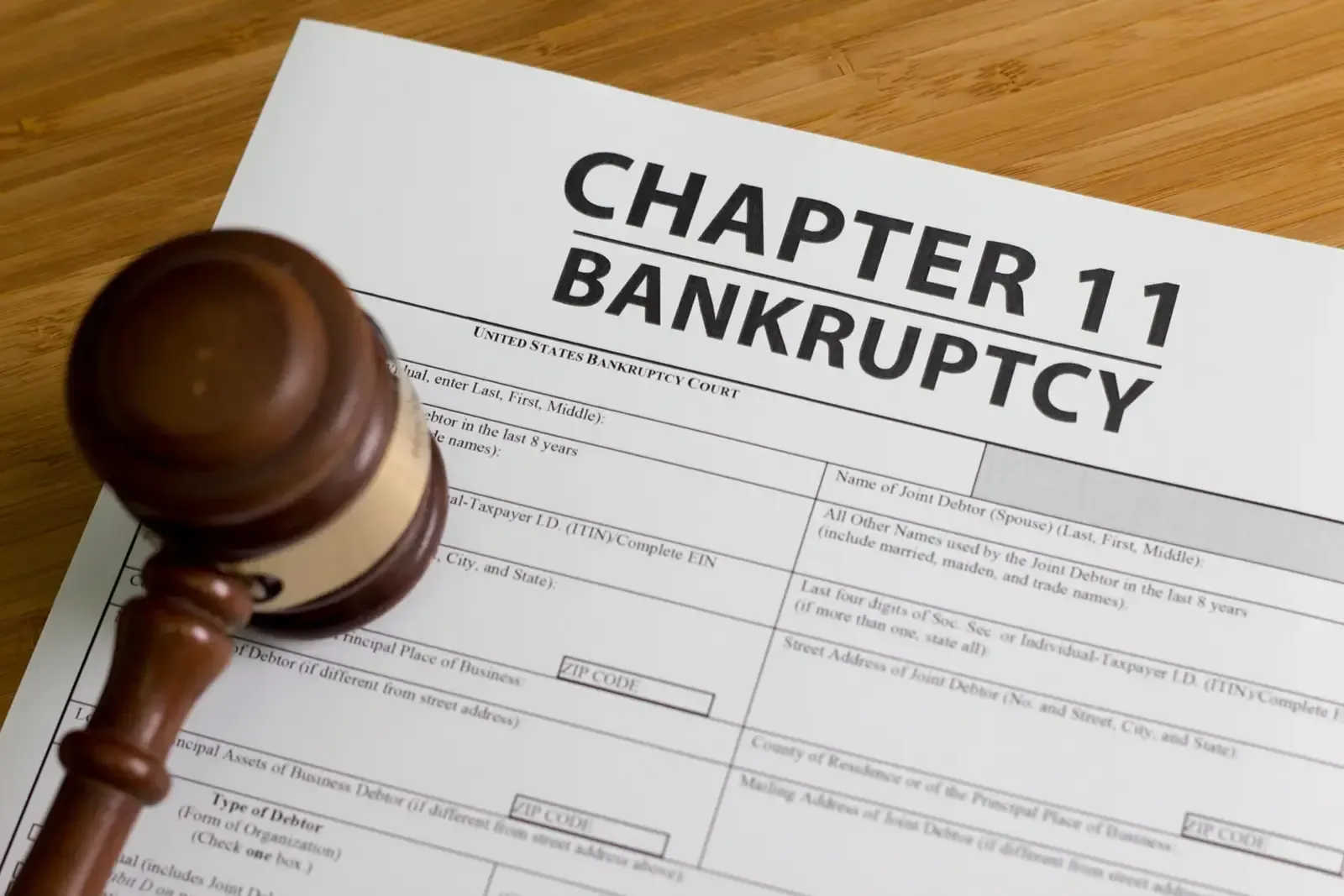 A judge's gavel is sitting on top of a chapter 11 bankruptcy form.