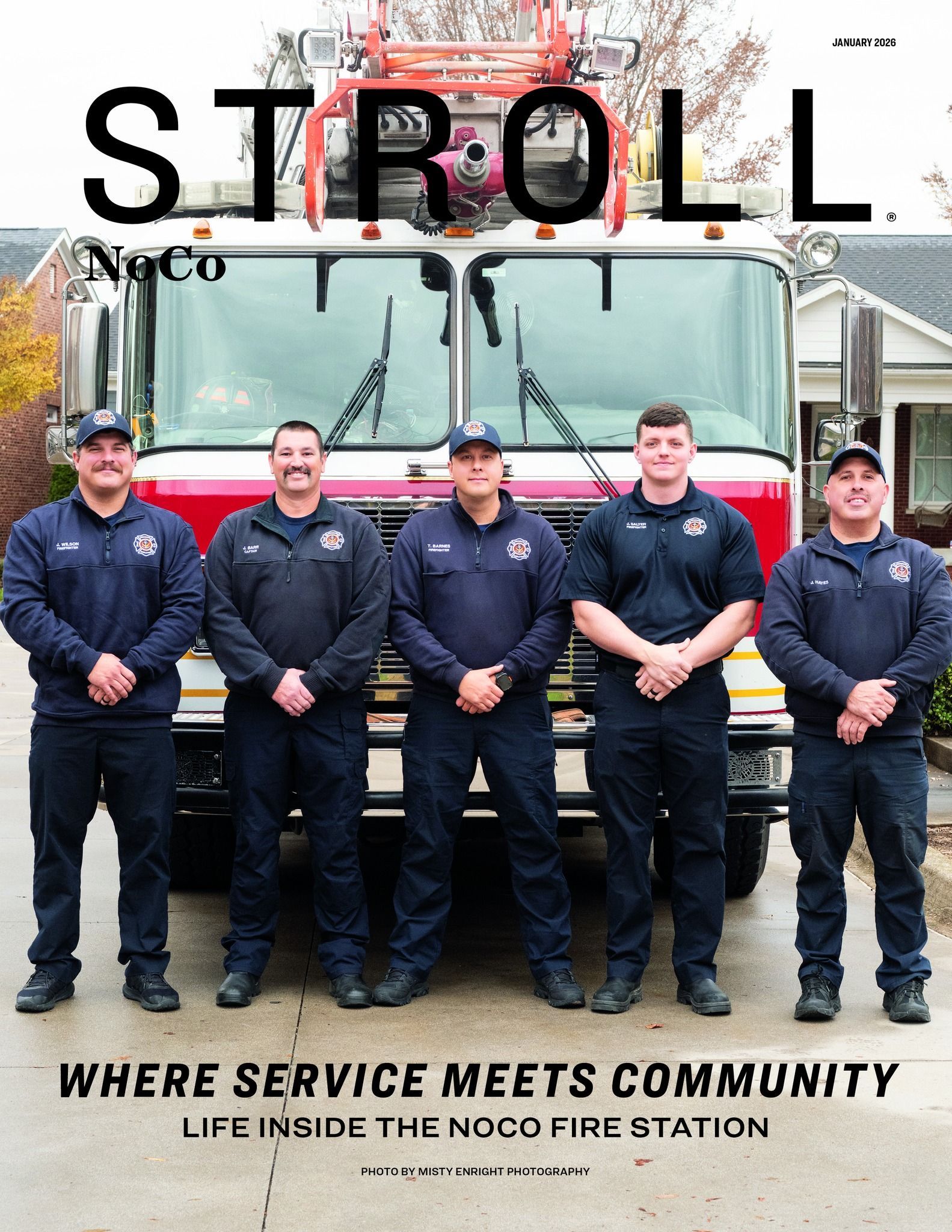 Five firefighters stand in front of a fire truck. 