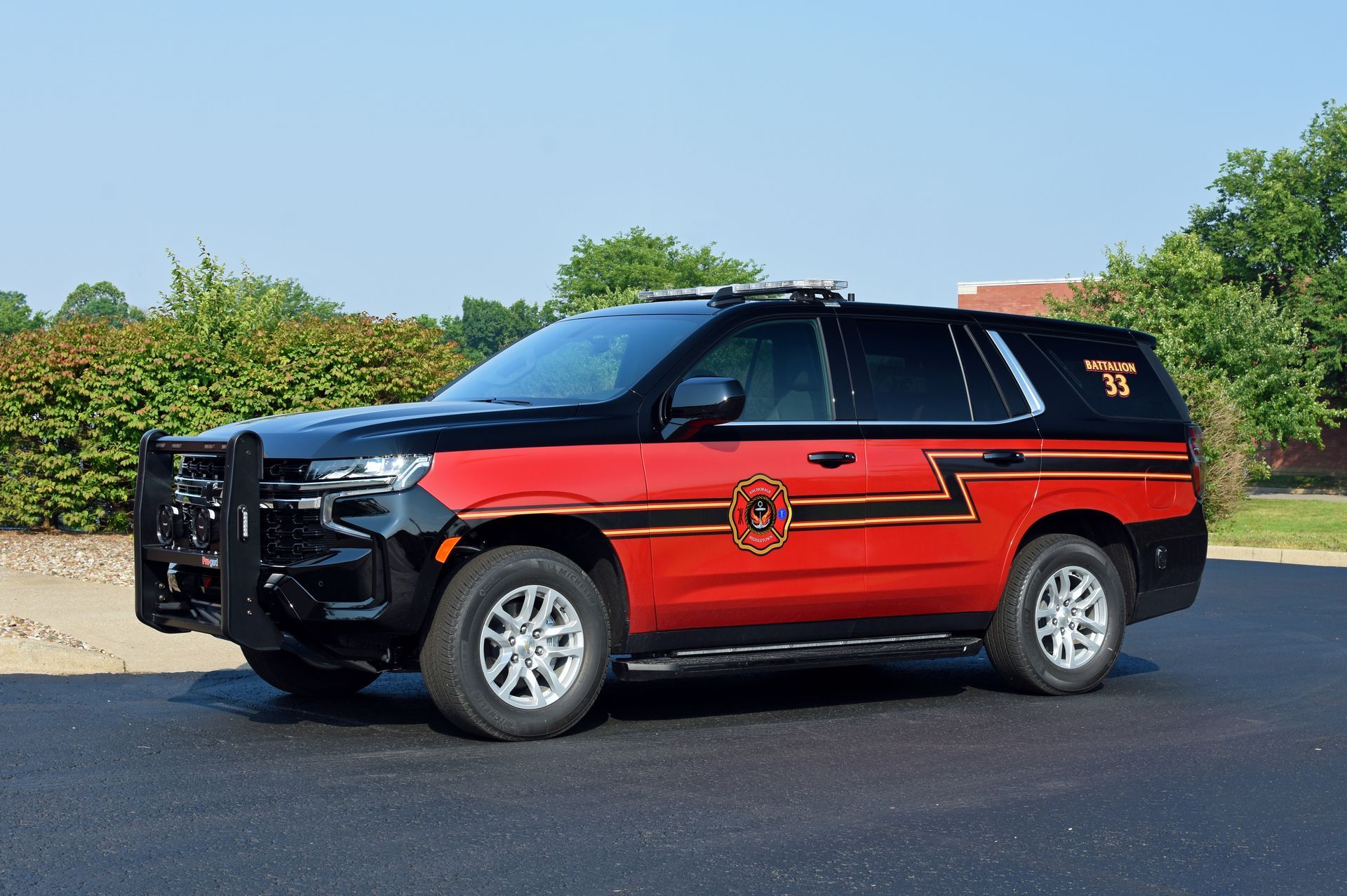Black and red fire department SUV parked on asphalt.