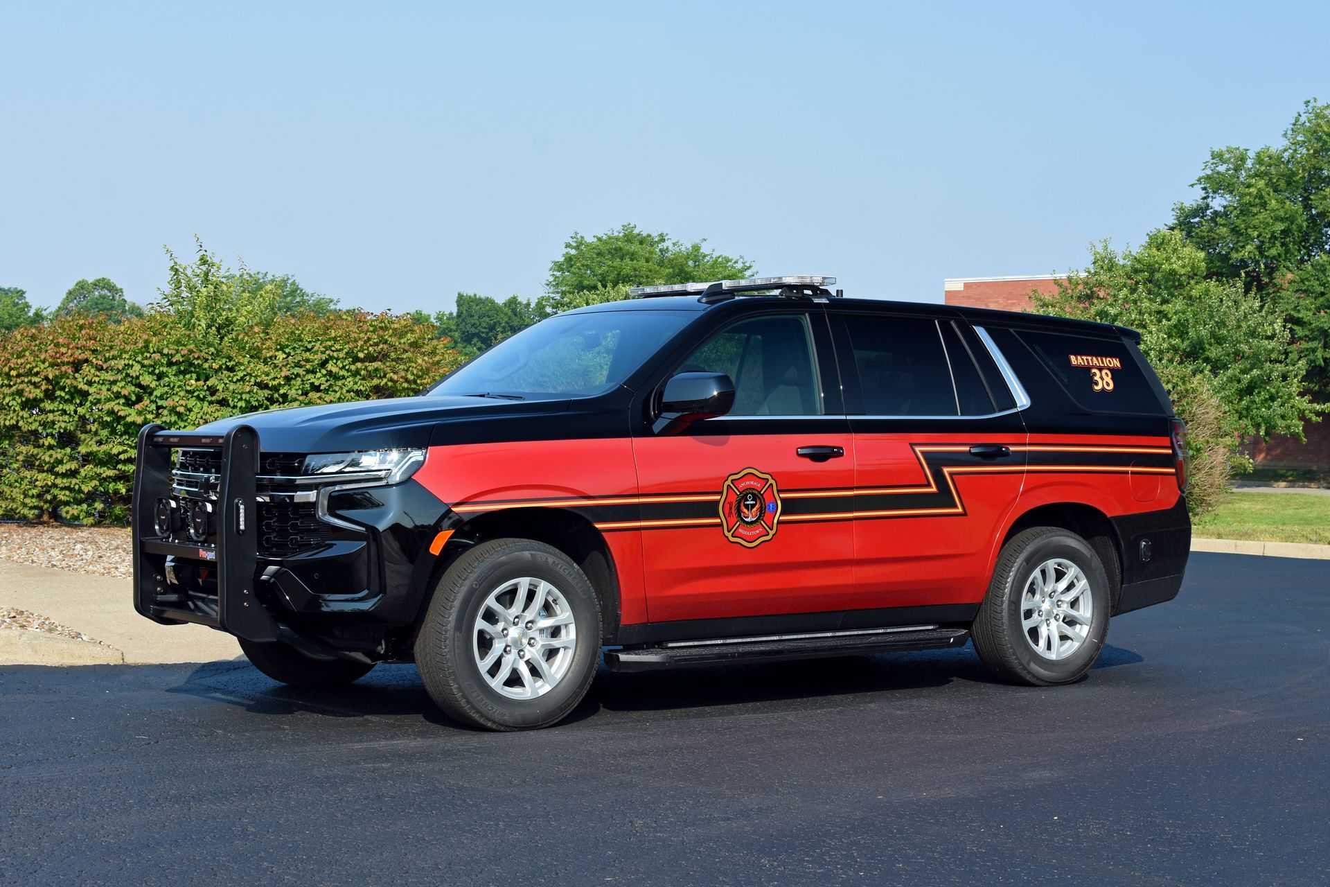 Black and red SUV with emergency lights, parked outside, likely for emergency services.