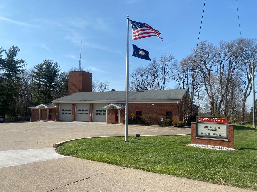 Fire station with flags waving, sunny day.