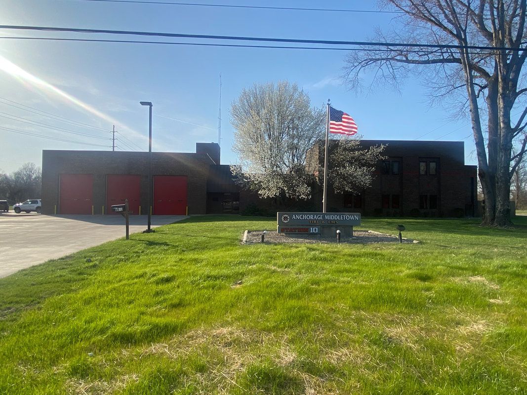 Fire station with red garage doors and an American flag.