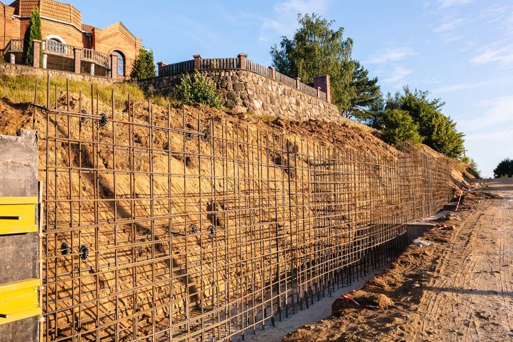 A Concrete Wall Is Being Built on The Side of A Hill — Magnum Steel In Crestwood NSW